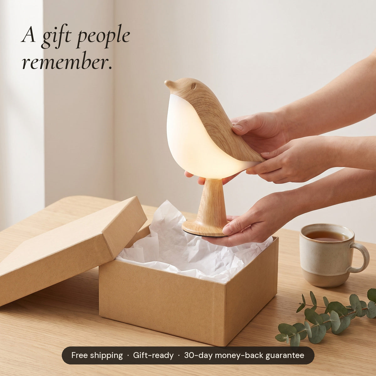 Hands unwrapping a Songlow bird lamp from tissue paper