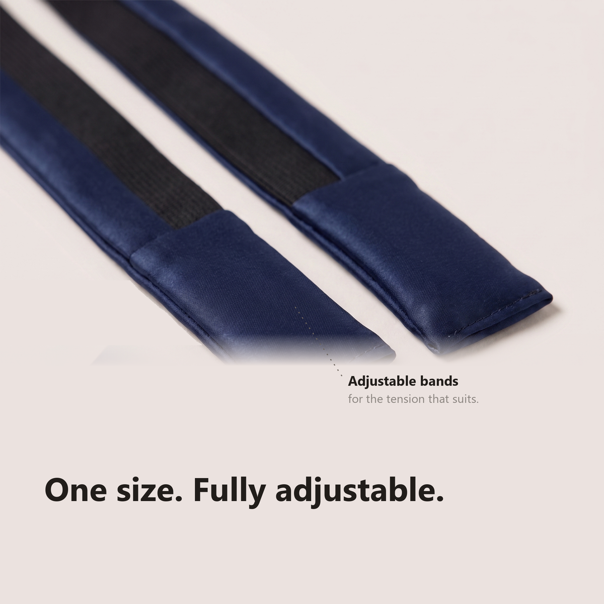 Macro of the two silk strap tails and their flat black elastic panels, labelled adjustable bands