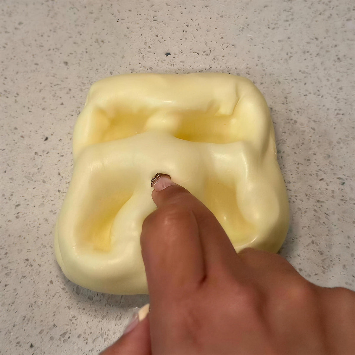 Deep finger dents staying in the yellow CHEDDI cheese squishy