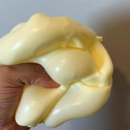 The yellow CHEDDI cheese squishy squeezed into a soft glossy blob in one hand