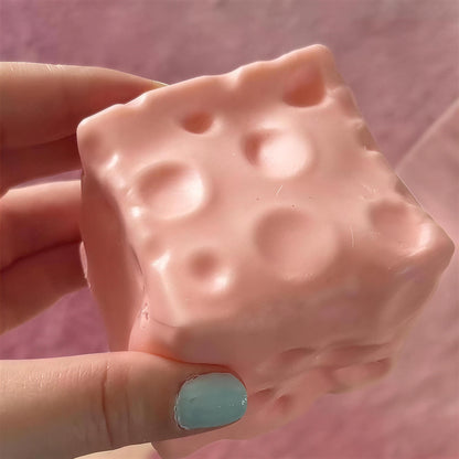 The strawberry pink CHEDDI cheese squishy held in one hand
