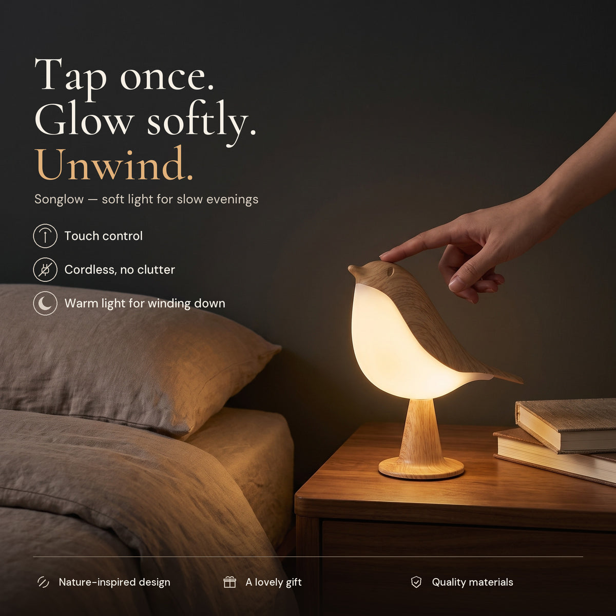 Songlow bird lamp glowing on a bedside table at night as a hand touches its head